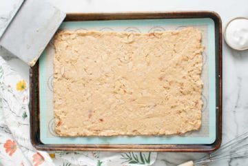 Cracker dough spread on a baking sheet.