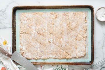 Cracker dough baking on a baking sheet.