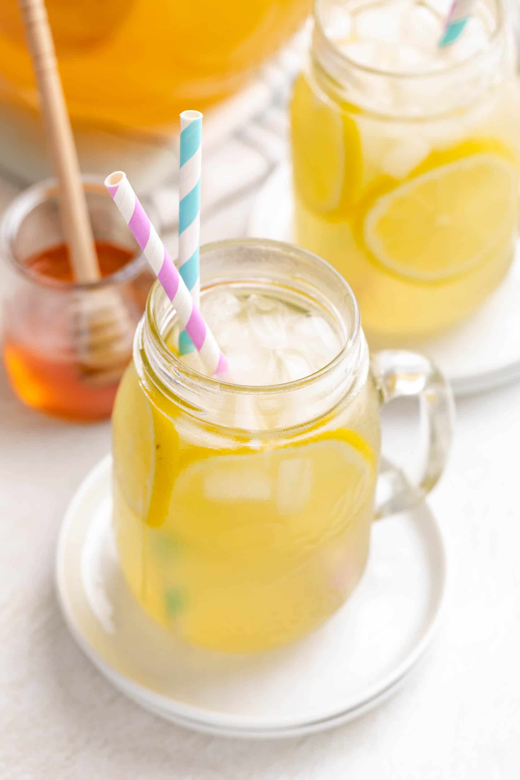 Two straws in a glass of honey lemonade.