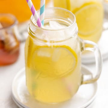 Side view of a glass of honey lemonade on ice.