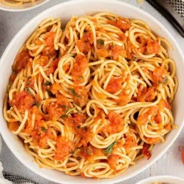 Top down view of a bowl of tomato basil pasta.