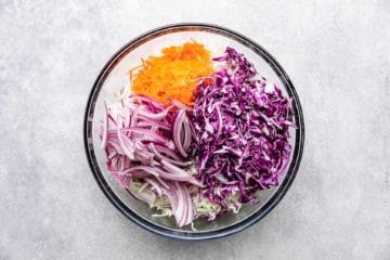 Cabbage, carrots and onions in a bowl.