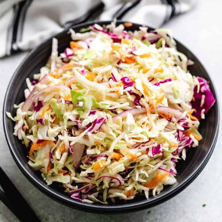 Close up view of a bowl of vinegar coleslaw.