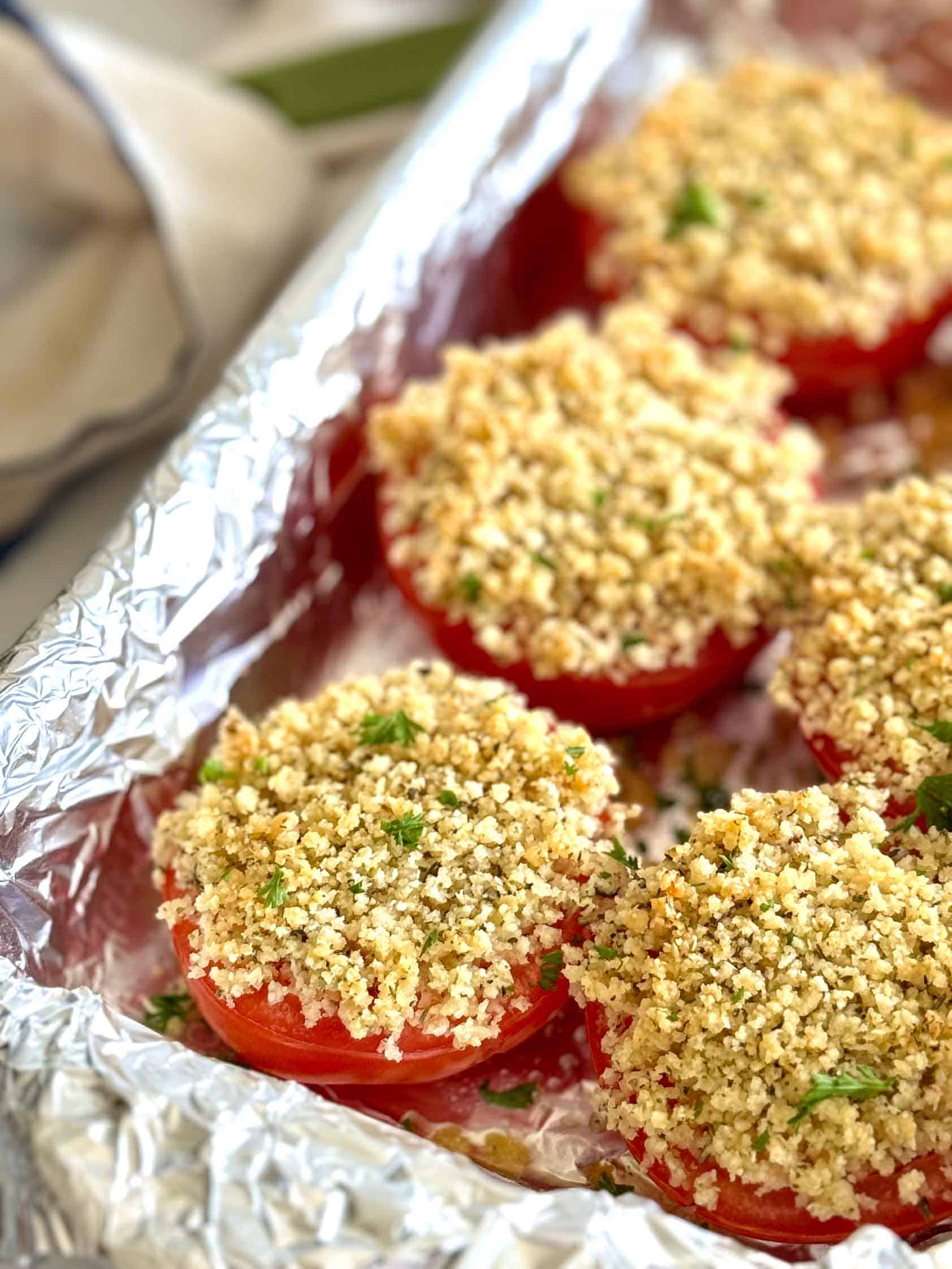 Cheesy crumb tomatoes in a foil lined pan.