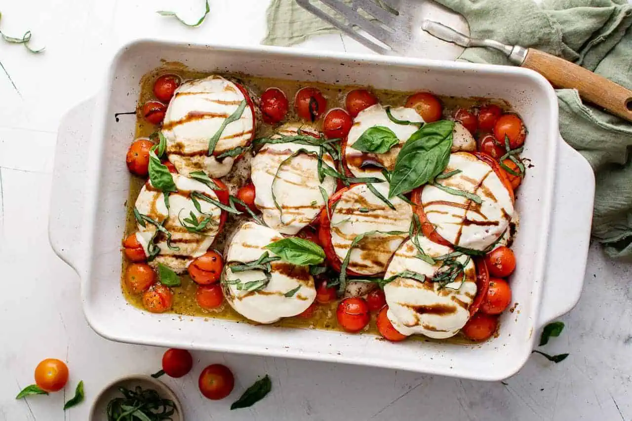 Chicken caprese in a white baking pan.