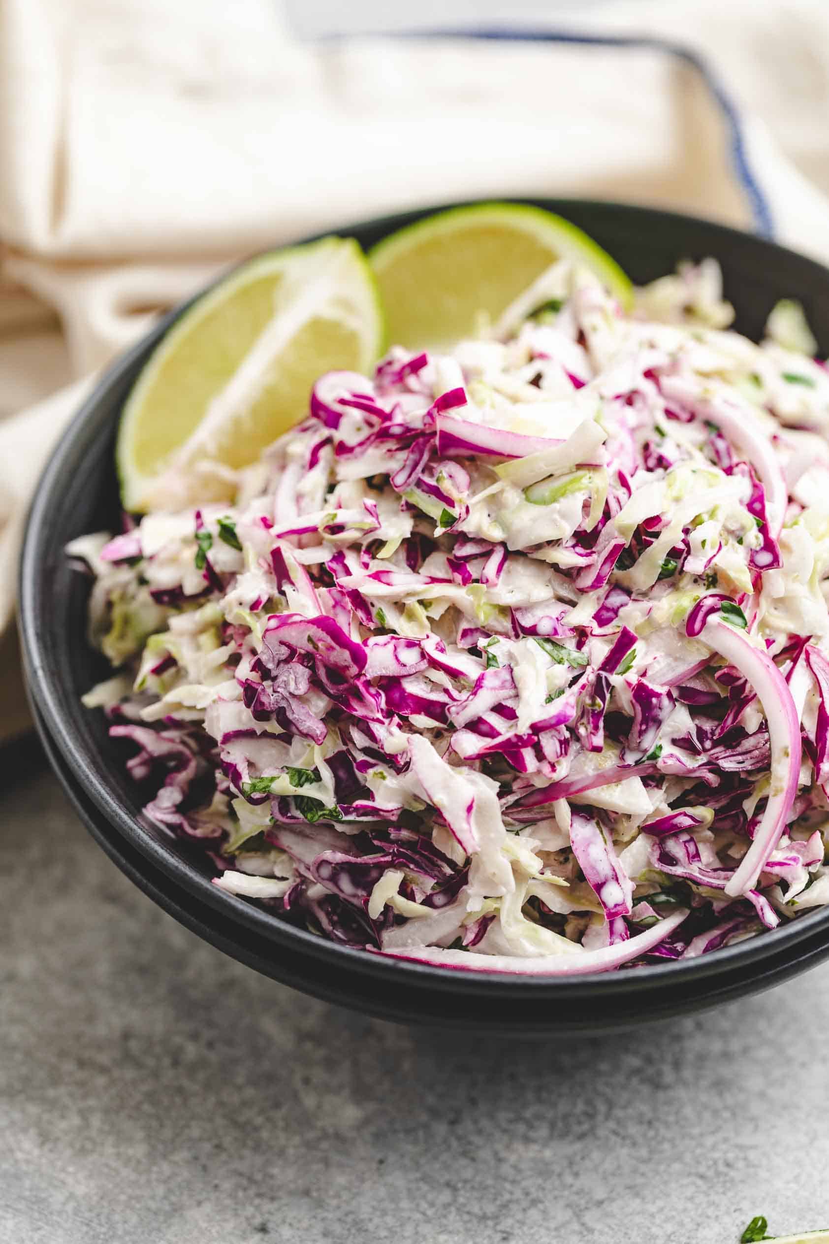 Limes in a bowl of cabbage slaw.