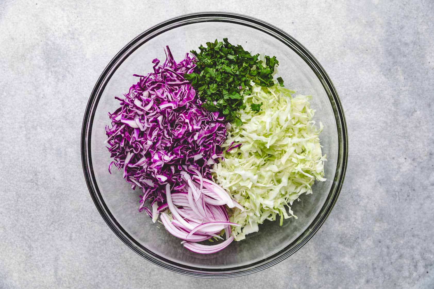 Cabbage, onions, and cilantro in a bowl.
