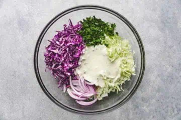 Lime dressing poured over cabbage, onions, and cilantro.