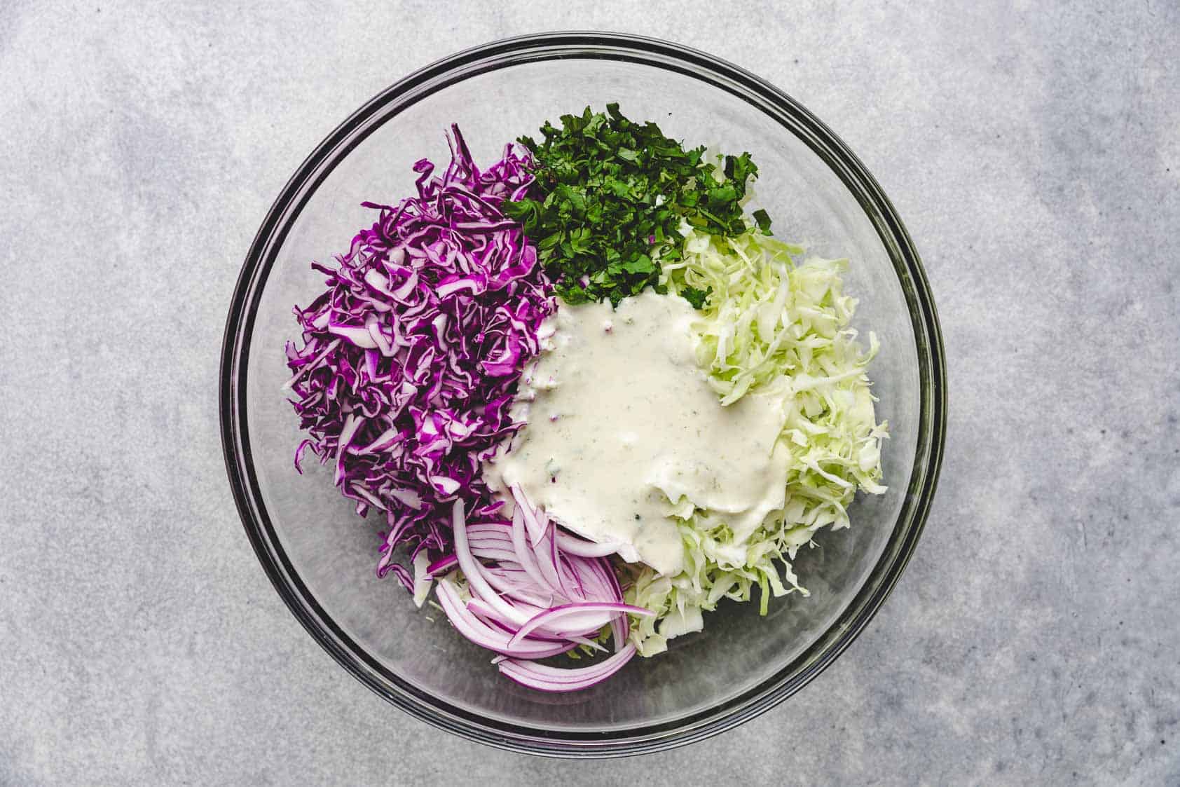 Lime dressing poured over cabbage, onions, and cilantro.