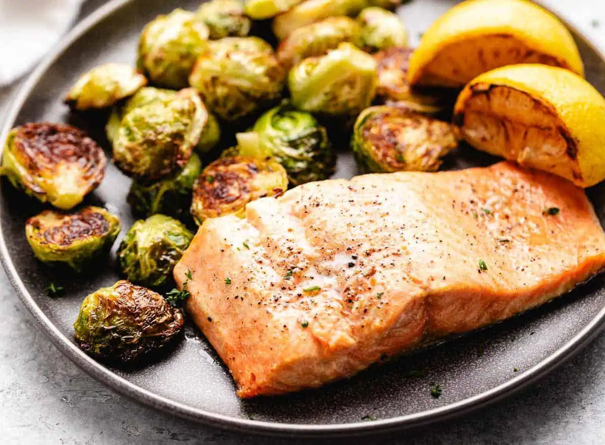 Salmon filet on a gray plate with lemon.