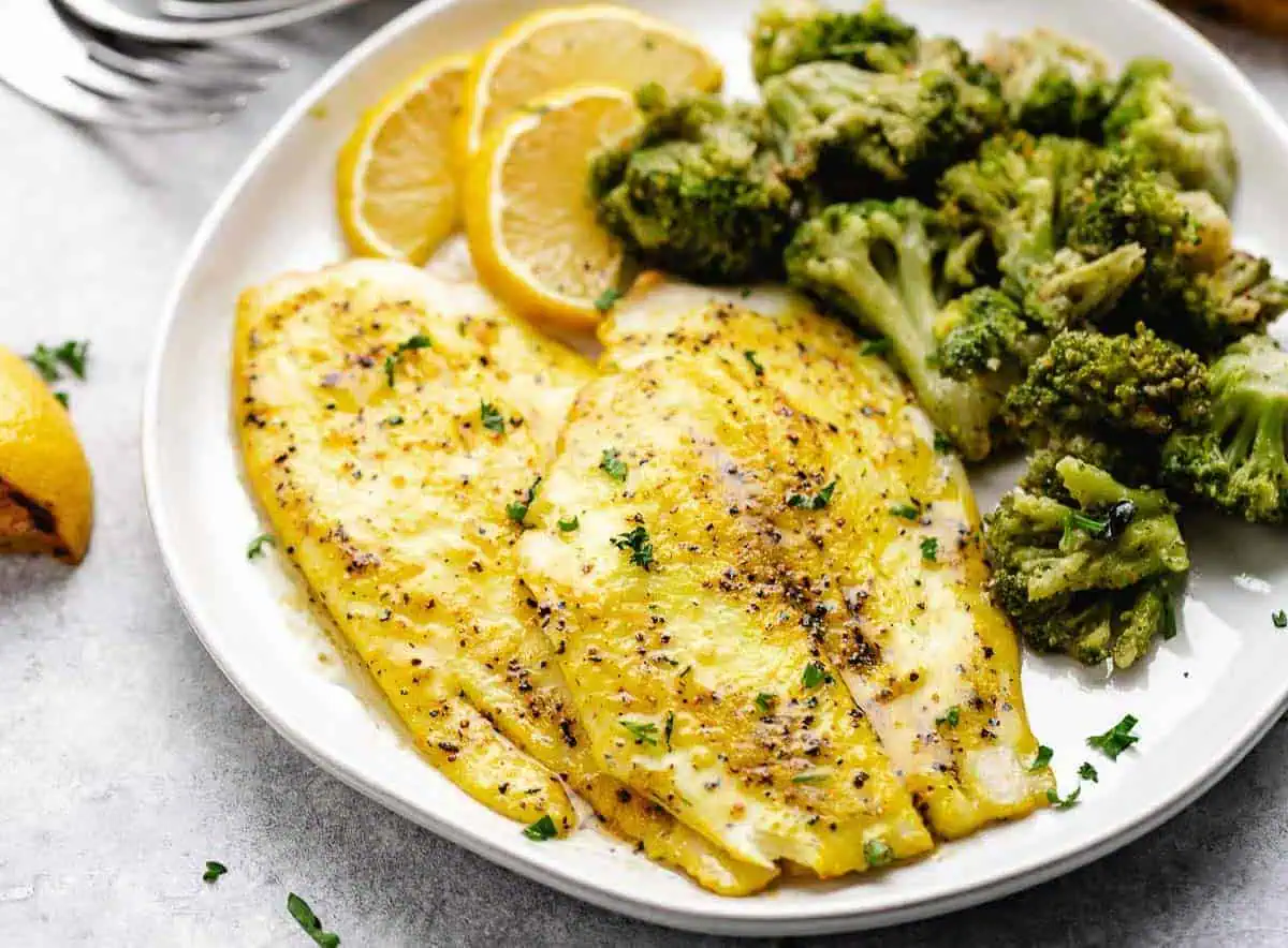 Two lemon pepper cod filets on a plate.