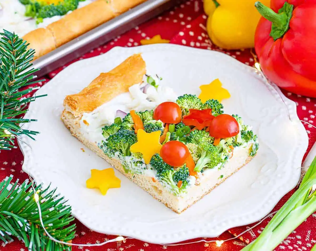 Slice of veggie pizza on a white plate.