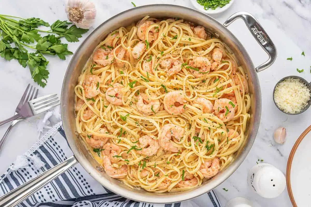 Garlic shrimp pasta in a metal skillet.