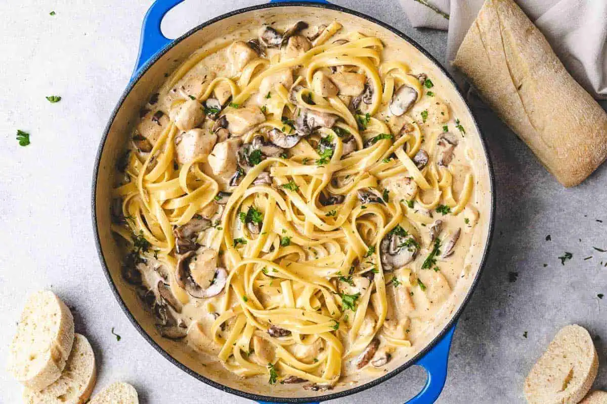 Chicken mushroom broccoli pasta in a blue pan.