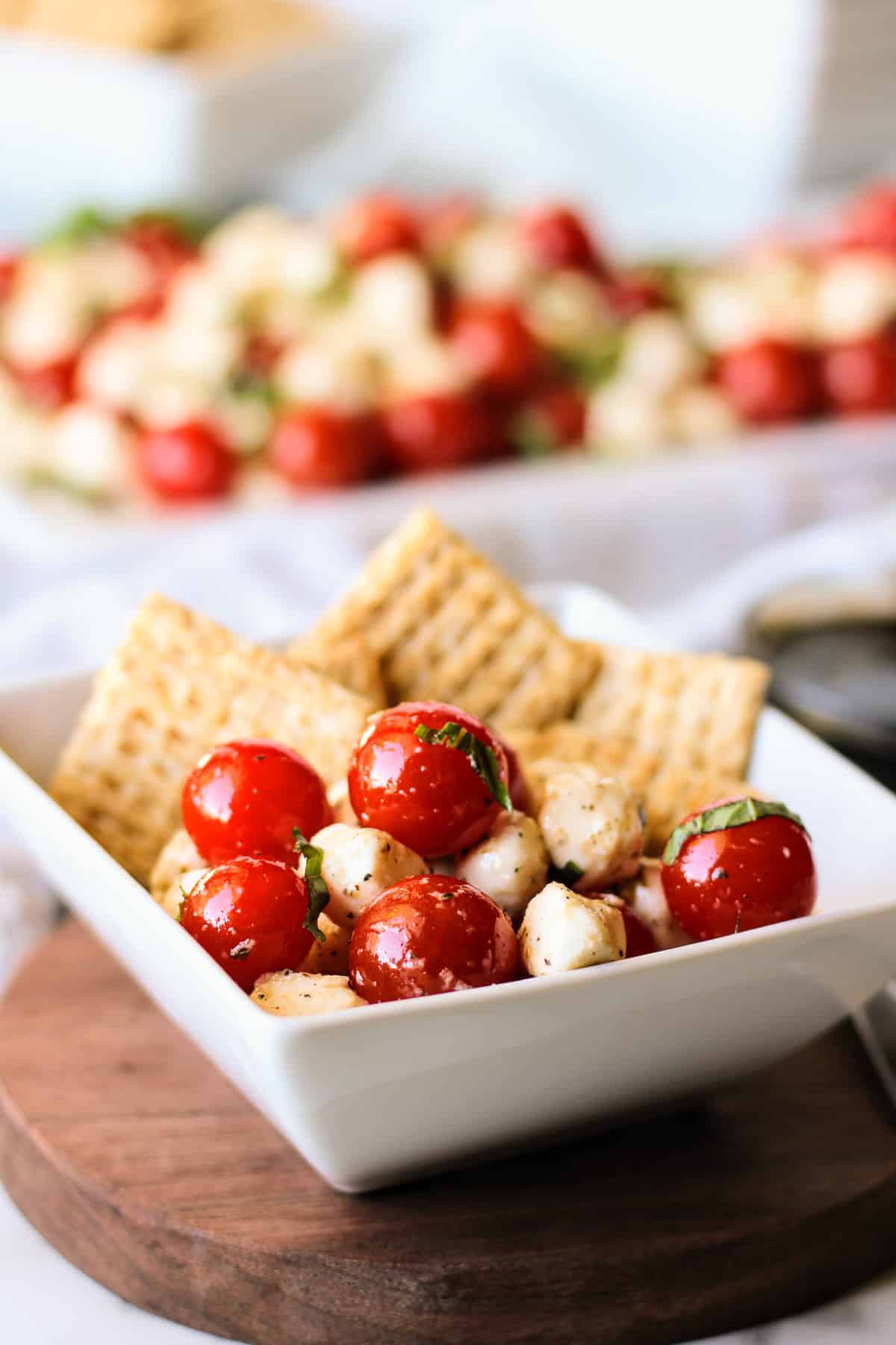 Bowl of tomato salad with crackers.