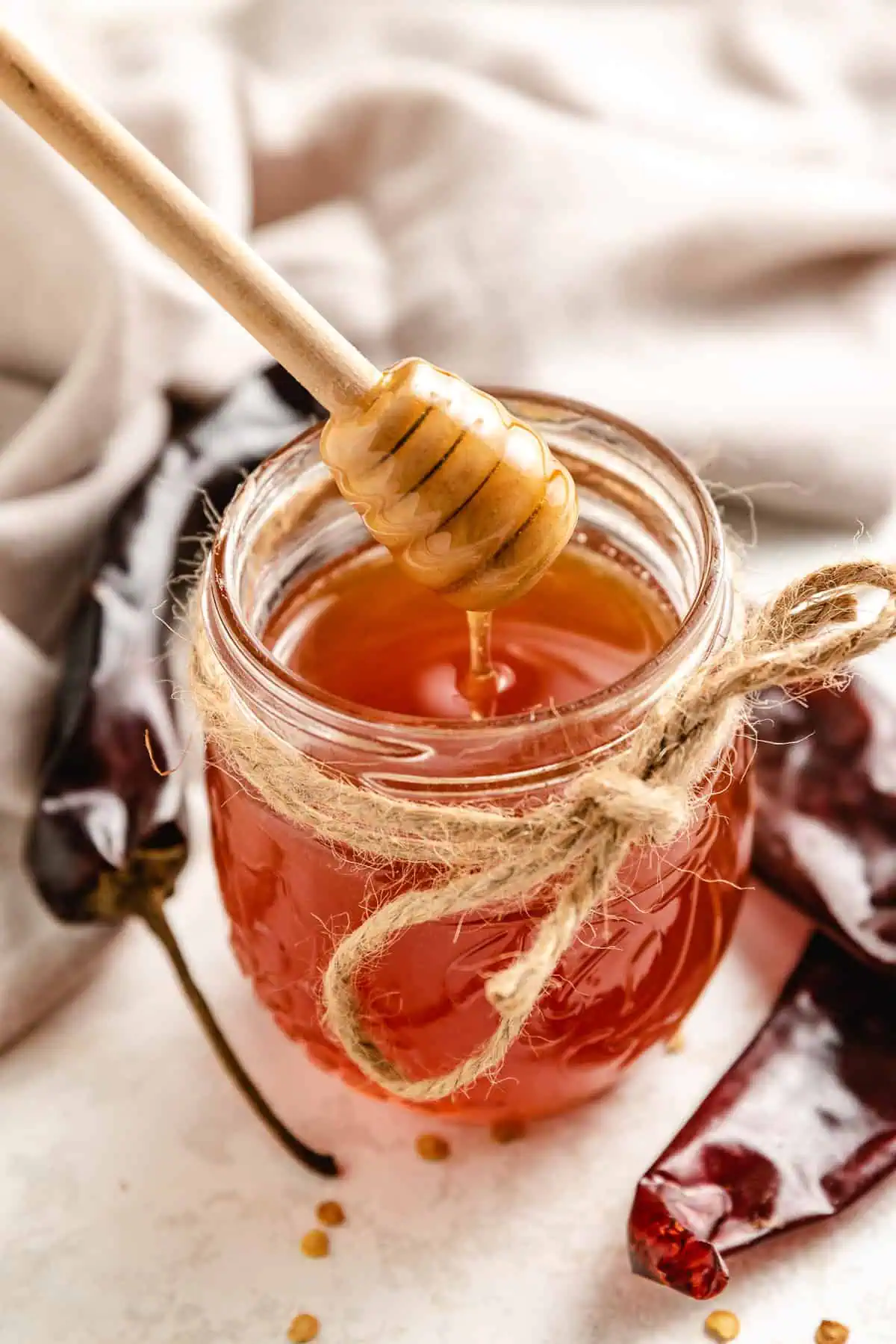 Honey stick inside a jar of honey.