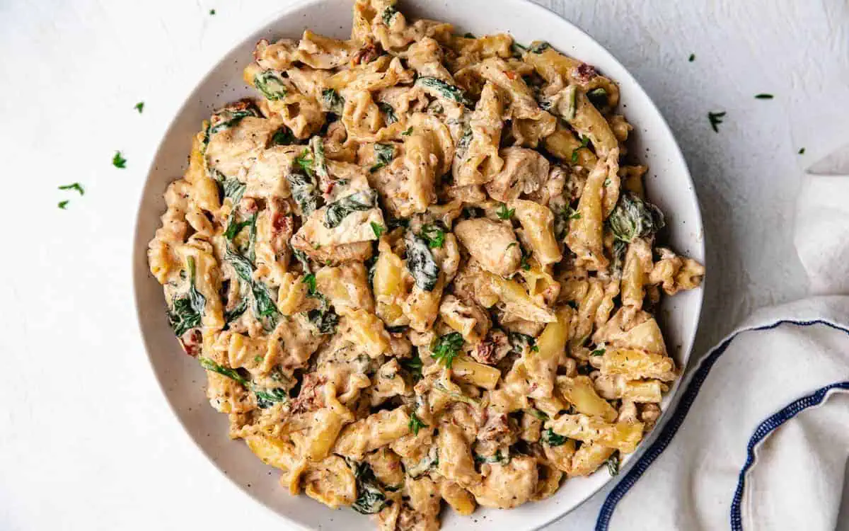 Serving plate filled with tuscan chicken pasta.