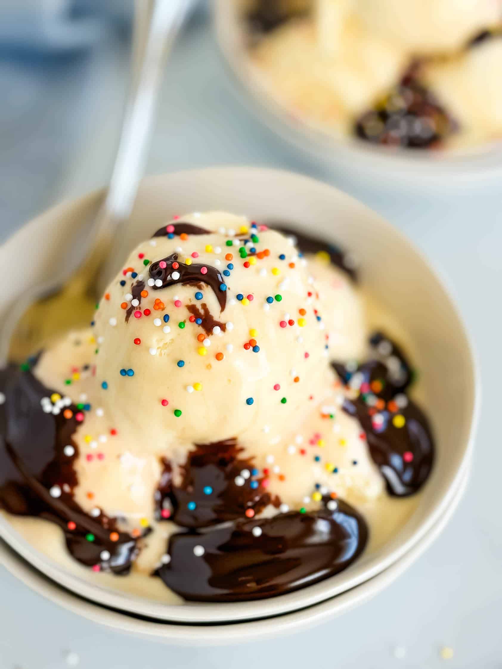 Hot fudge and vanilla ice cream in a bowl.