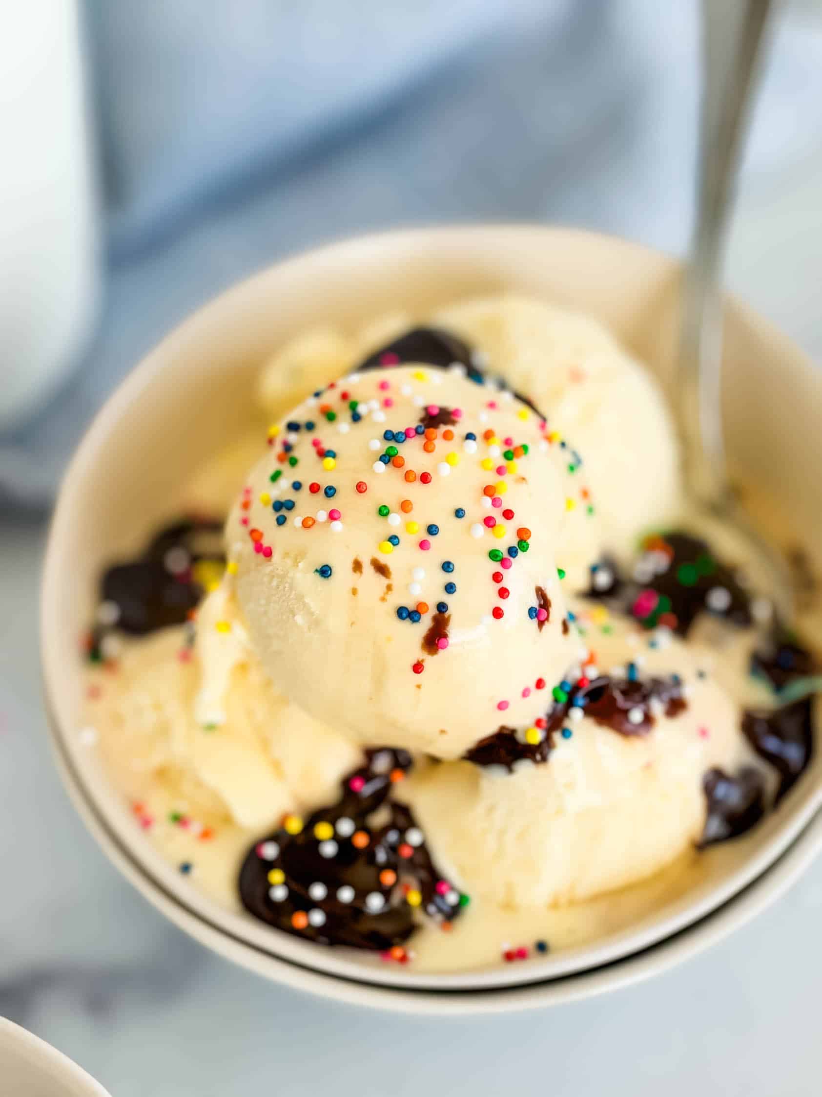 Colorful sprinkles on top of vanilla ice cream.