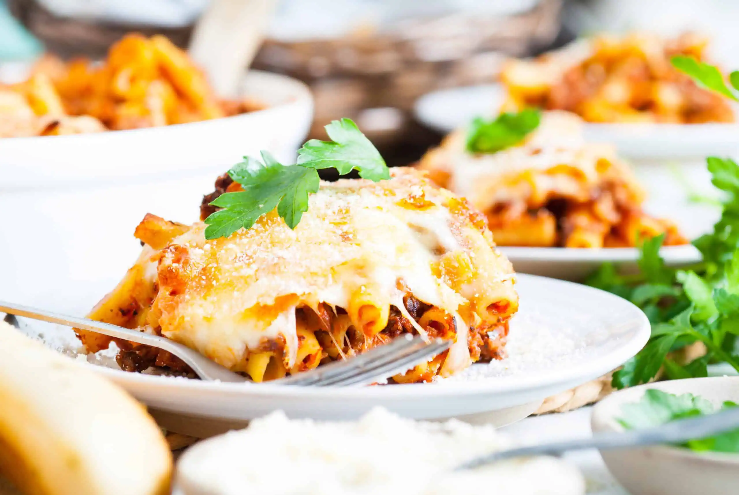 Scoop of cheesy baked ziti on a plate.