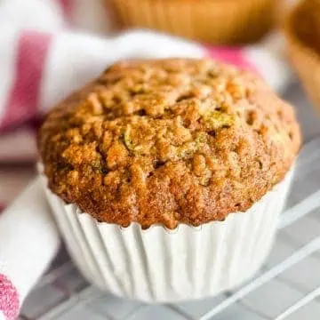 Close up view of a zucchini muffin next to a towel.