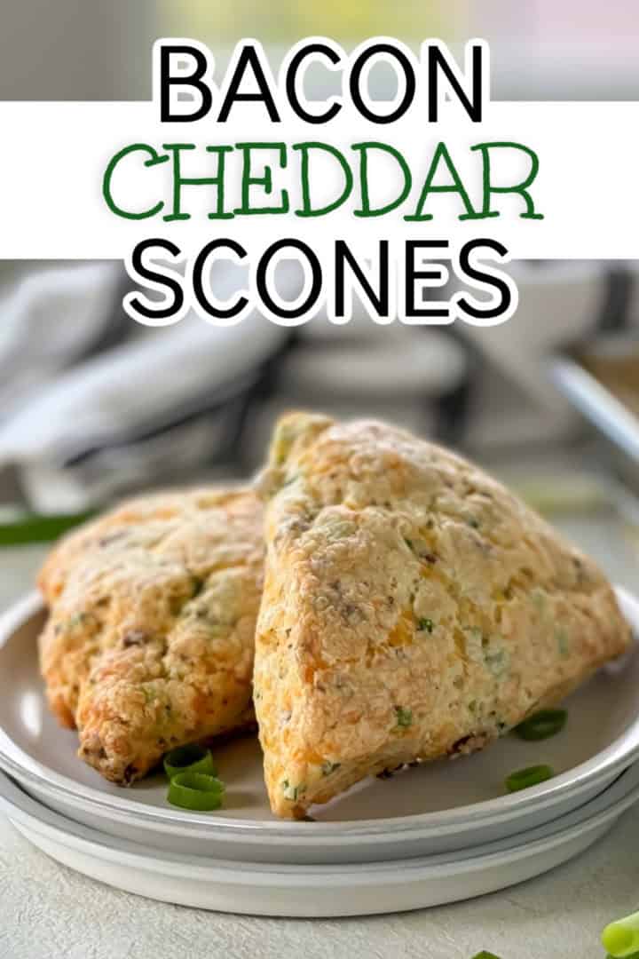 Two bacon cheddar scones on a white plate, with the text 'bacon cheddar scones' overlaid in bold letters.