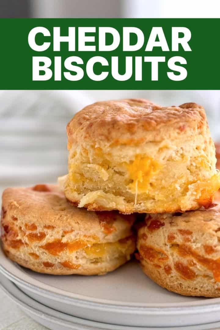 A plate of warm, homemade cheddar biscuits with a focus on the melty cheese inside.