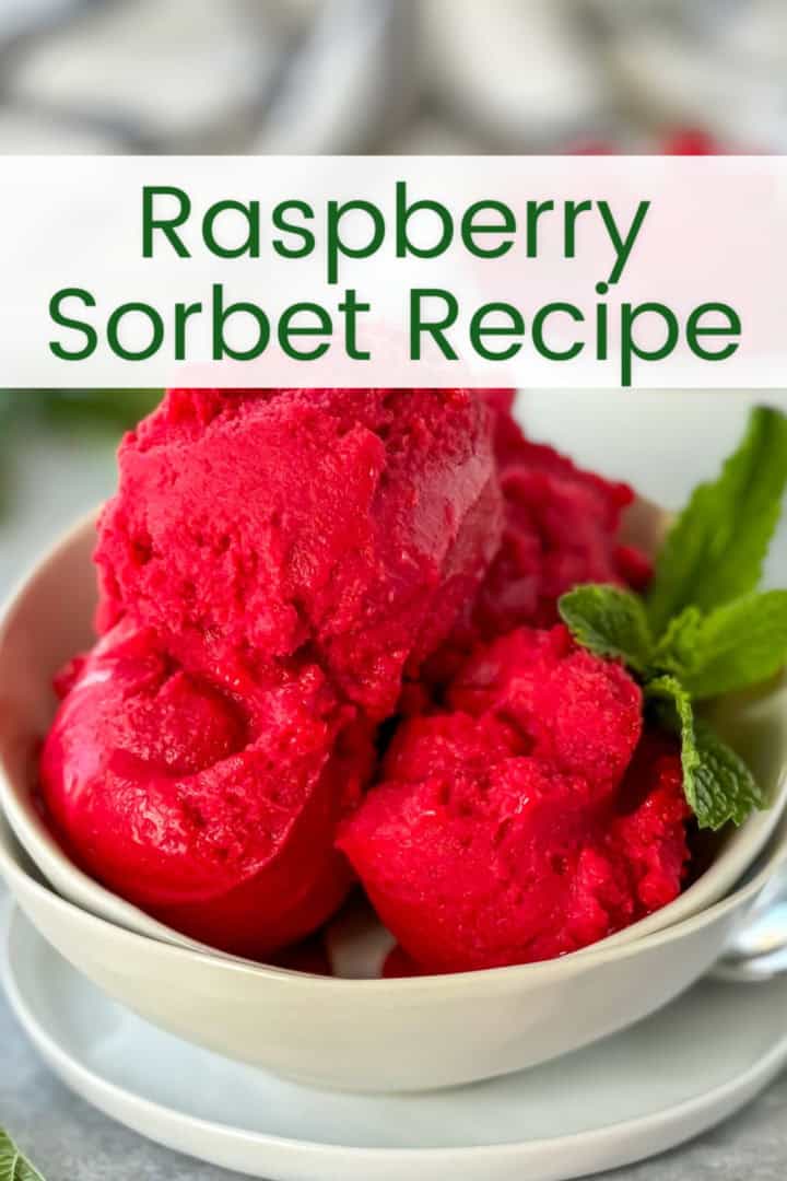 Close-up of raspberry sorbet scoops in a bowl, garnished with fresh mint leaves, with the text 'raspberry sorbet recipe' overlayed.