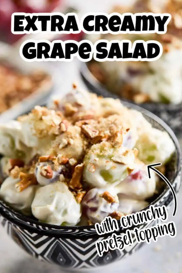 Extra creamy grape salad with crunchy pretzel topping, served in a decorative bowl.