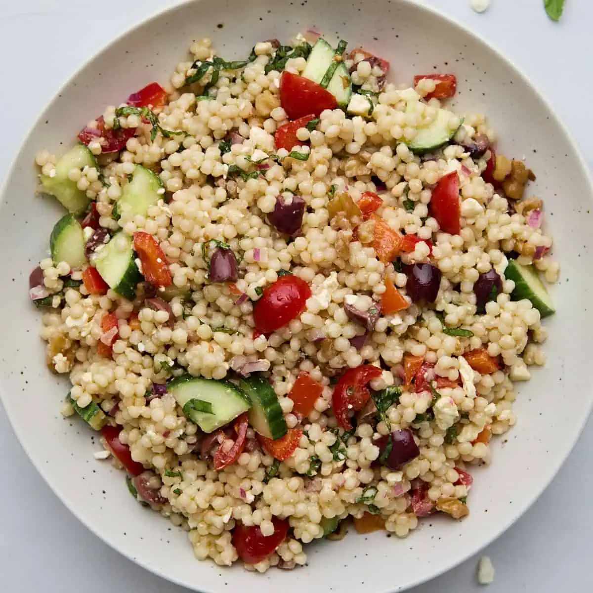 Healthy summer couscous salad with pearl couscous, fresh vegetables, and a tangy lemon dressing.