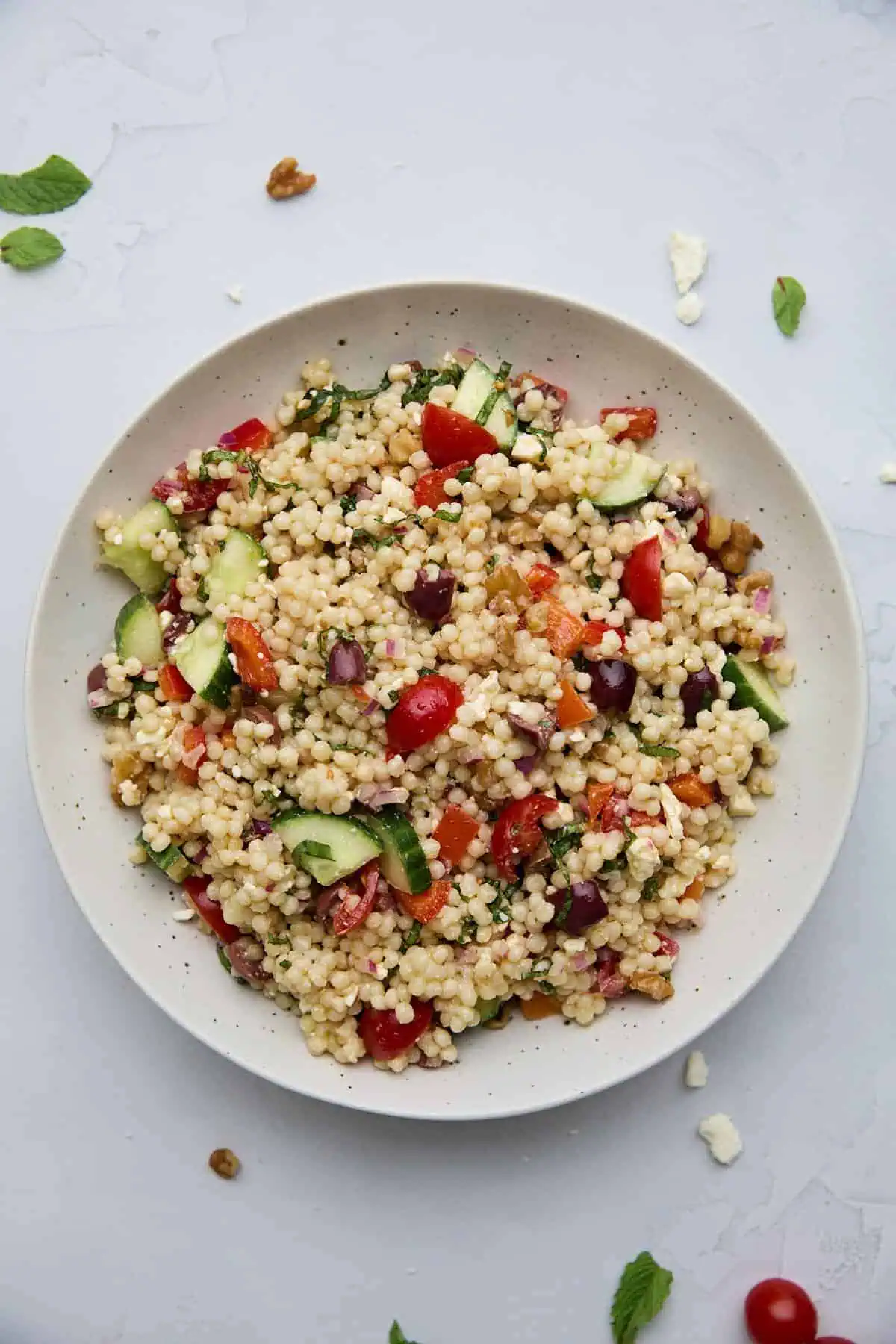 Close-up view of a refreshing pearl couscous salad with fresh vegetables and herbs, perfect for a healthy meal.