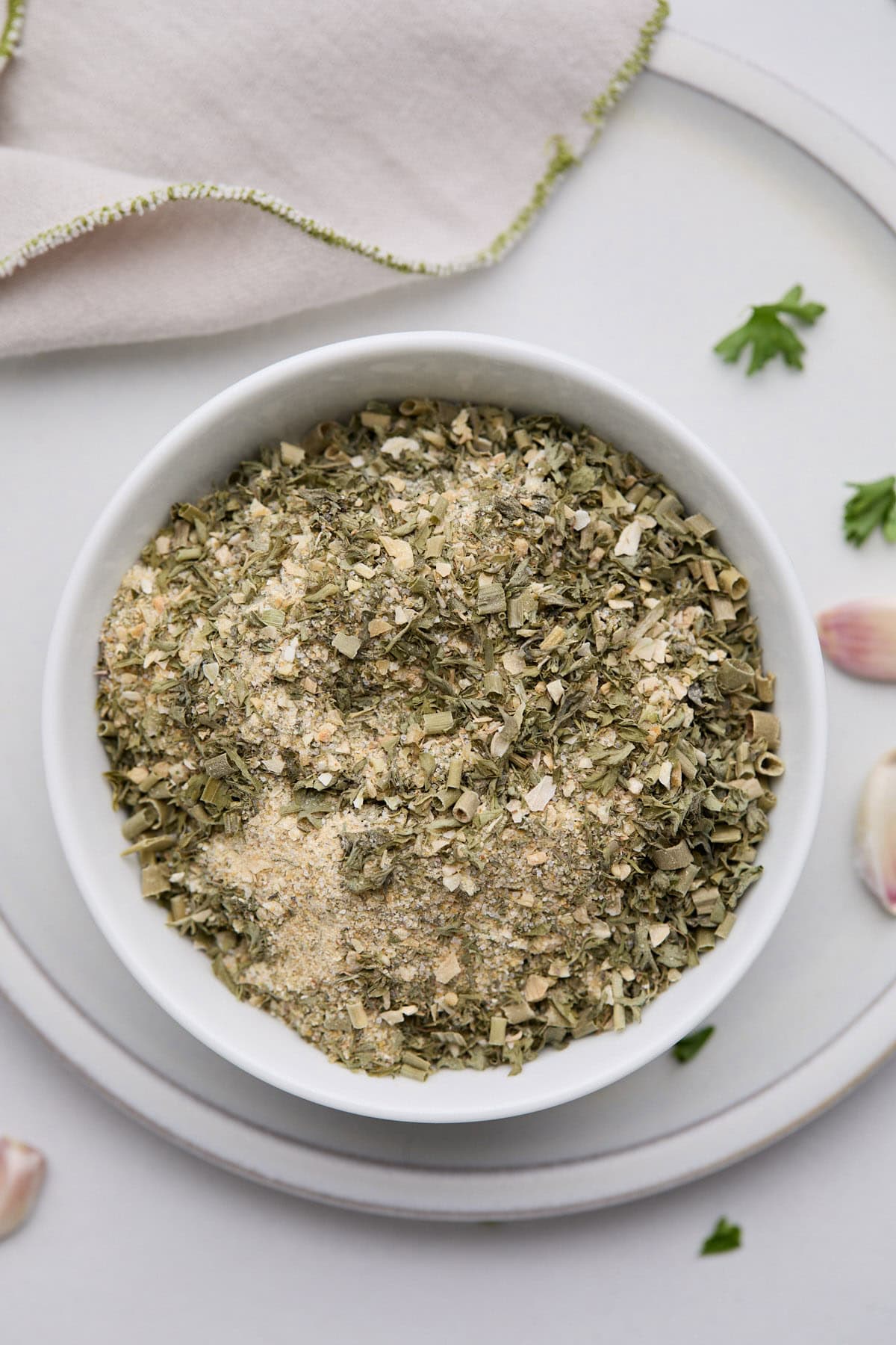 A small bowl of herb-filled ranch dressing mix, with a napkin and spoon in the background.