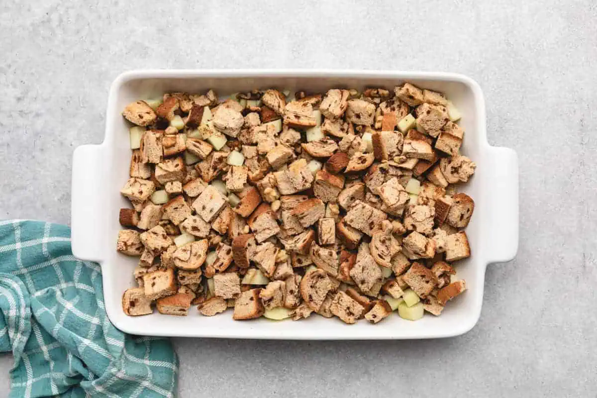 Bread pieces and apple chunks in a baking dish.