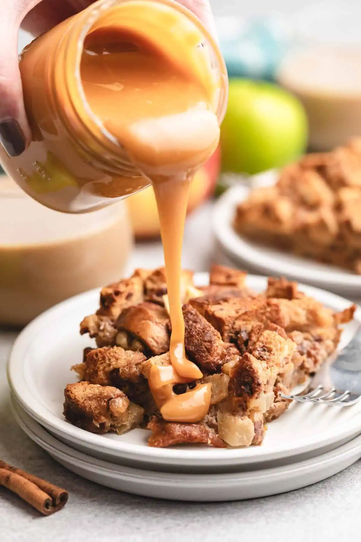 Caramel sauce being poured over bread pudding.