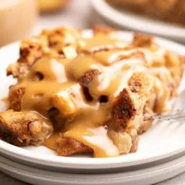 Close up view of apple cinnamon bread pudding topped with caramel sauce.