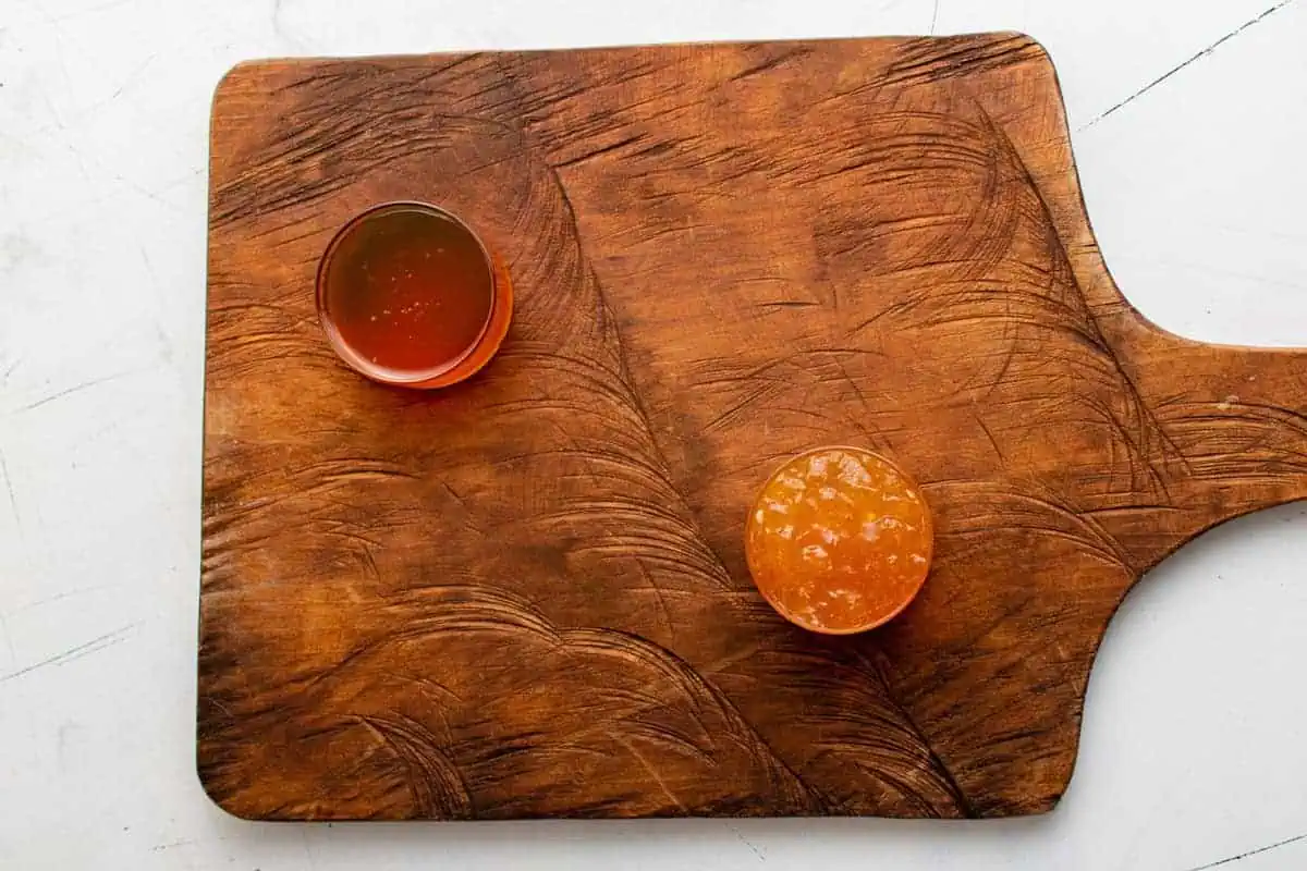 Honey and jam on a wooden board.