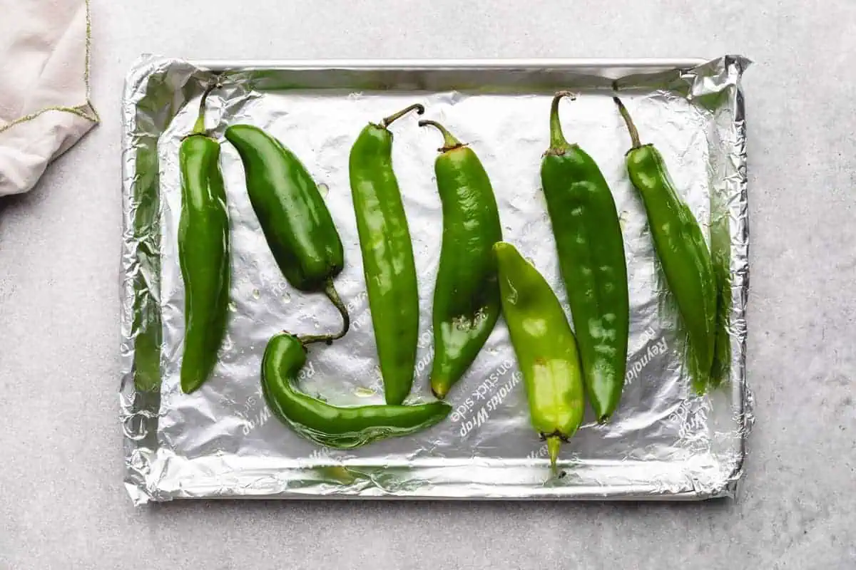 Hatch chiles arranged on a baking sheet.