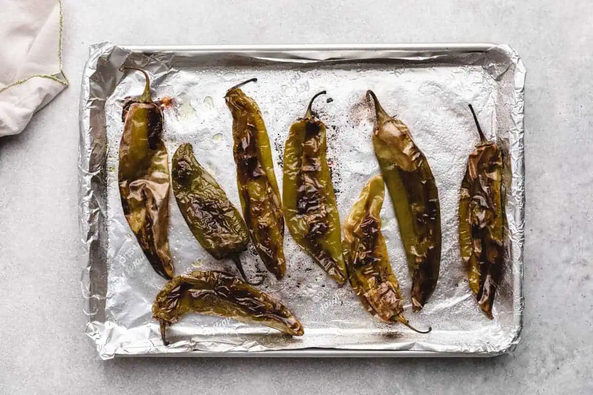 Roasted hatch chiles on a baking sheet.