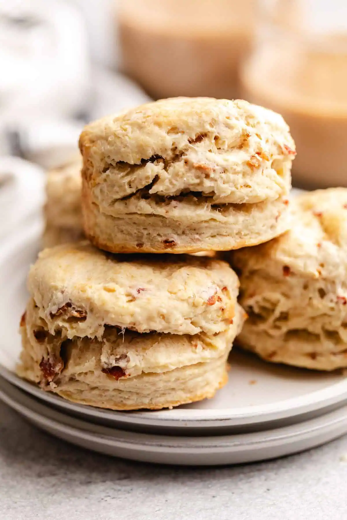 Maple bacon biscuits stacked on a plate.