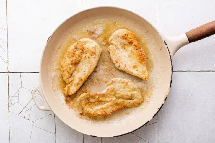 Chicken pan frying in a skillet.