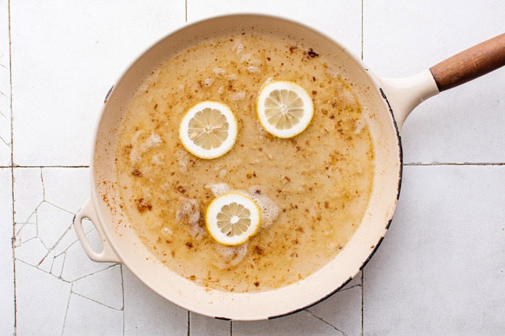 Chicken Piccata Lemon juice, wine, and garlic in a pan.