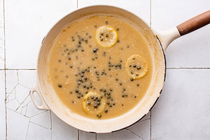 Chicken Piccata Capers added to a pan of lemon sauce.