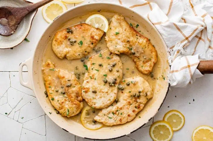 Overhead view of chicken piccata in a skillet.