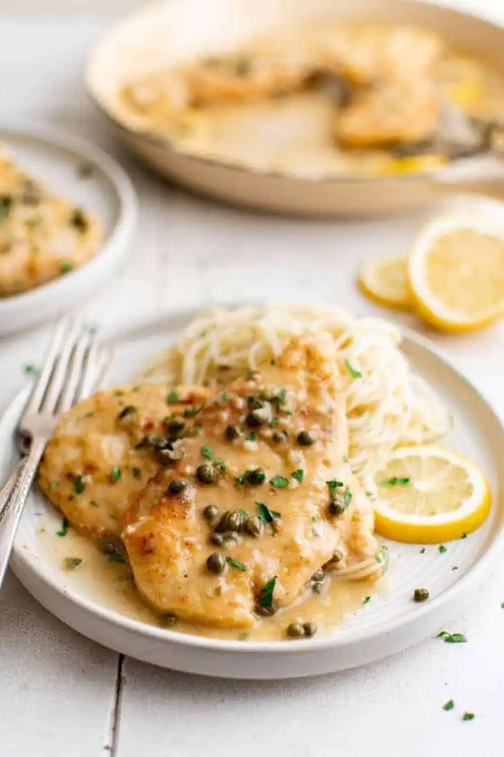 Chicken piccata over pasta.