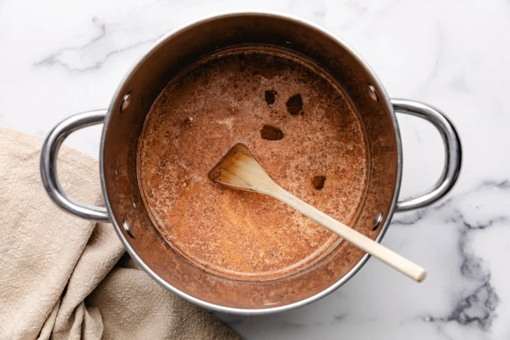 Cinnamon, maple, and vanilla added to a pan of milk.