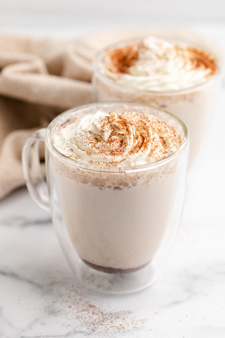 Side view of mugs filled with spiced milk steamer.