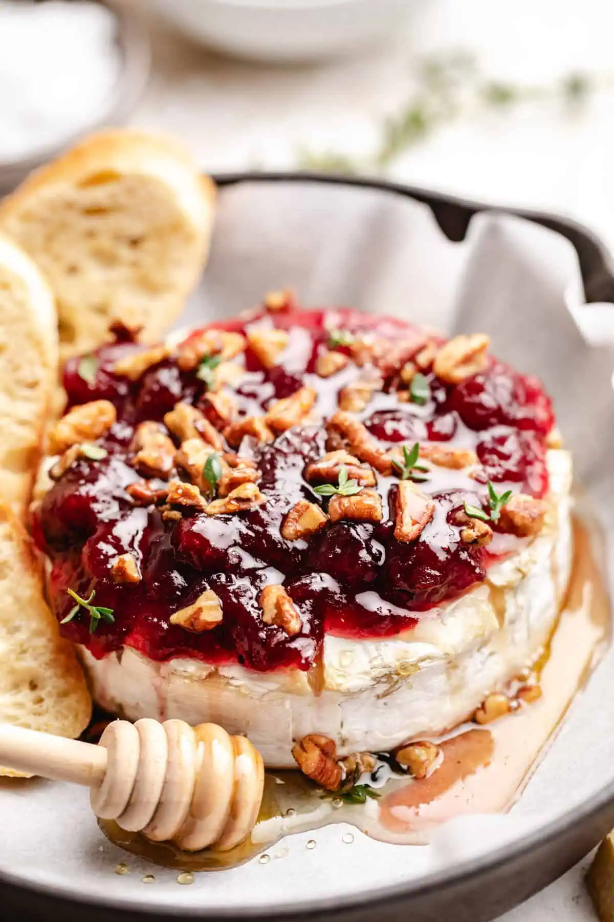 Holiday baked brie next to toasted bread.