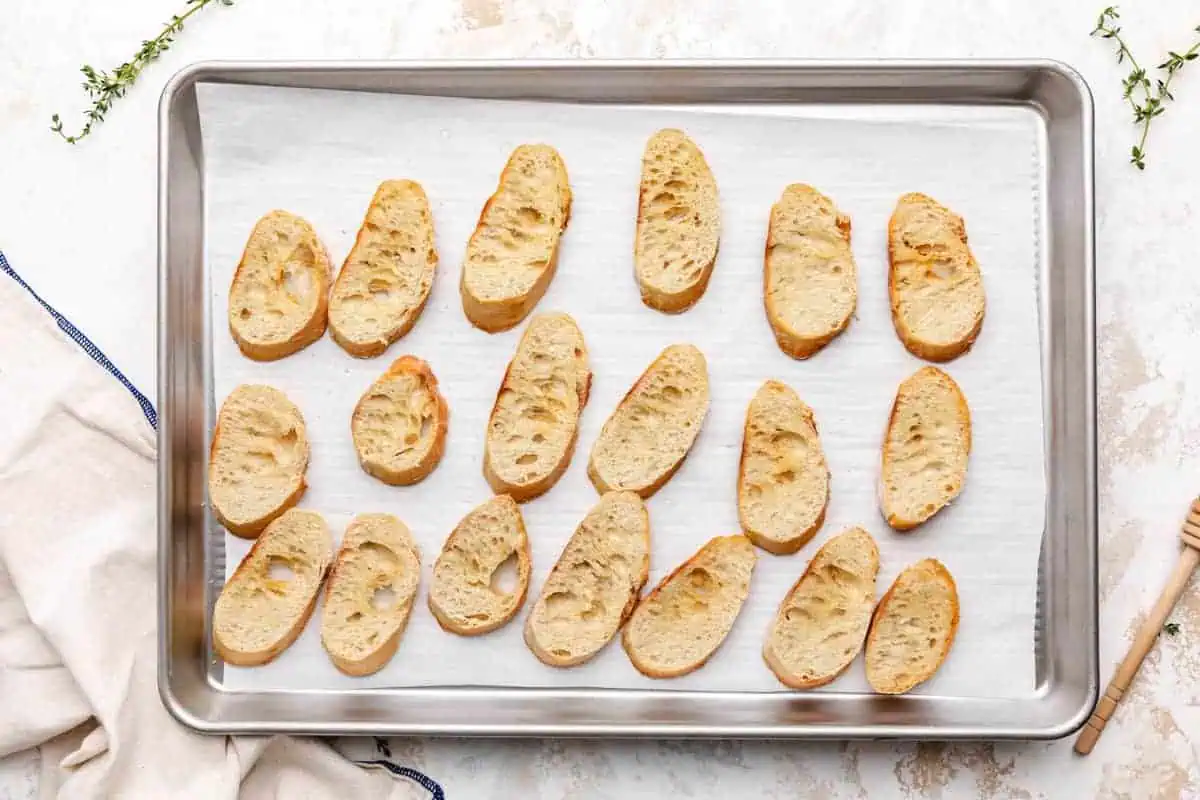 Toasted bread slices on a sheet pan.