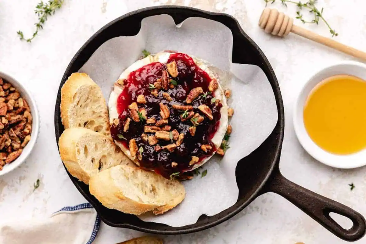 Top down view of brie, cranberry sauce and pecans.