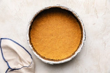 Graham cracker crust in a springform pan.